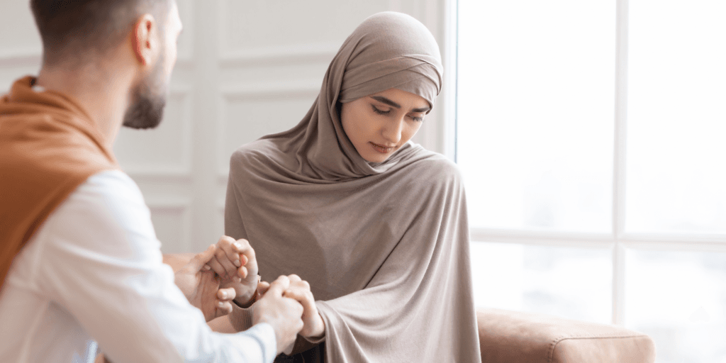 How to turn down a second date: be upfront. A man holds hands with a woman wearing a chador who appears sad at the news.