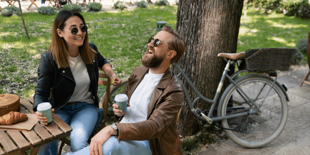 Top dating apps for single parents reviewed. A female and male appear to have a good time on their date over coffee and pastries in the park.