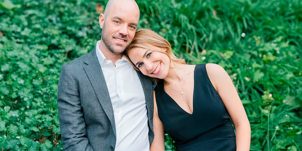 A woman in a black dress leans on her date smiling after connecting through Tawkify's matchmaking service.